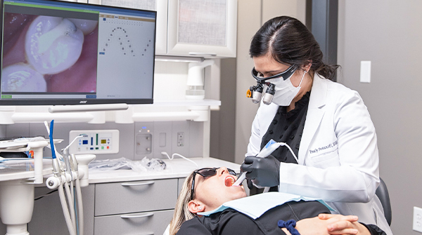 Dentist using an intraoral camera to capture images in a patient’s mouth