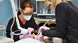 dentist and hygienist using a dental laser on a patient