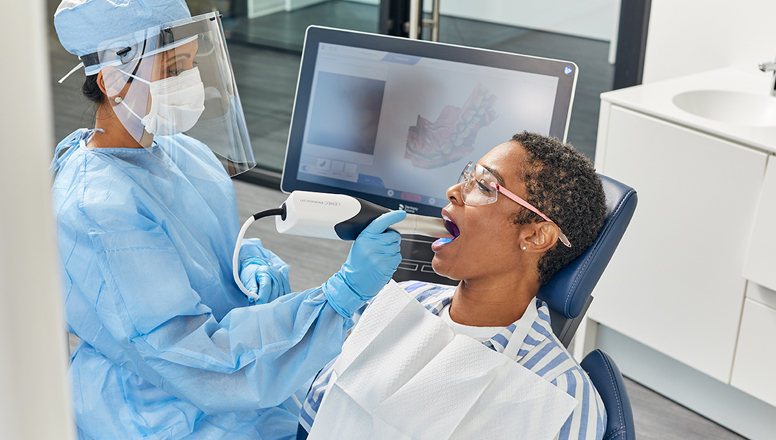 dental technician using a digital scanner with a patient